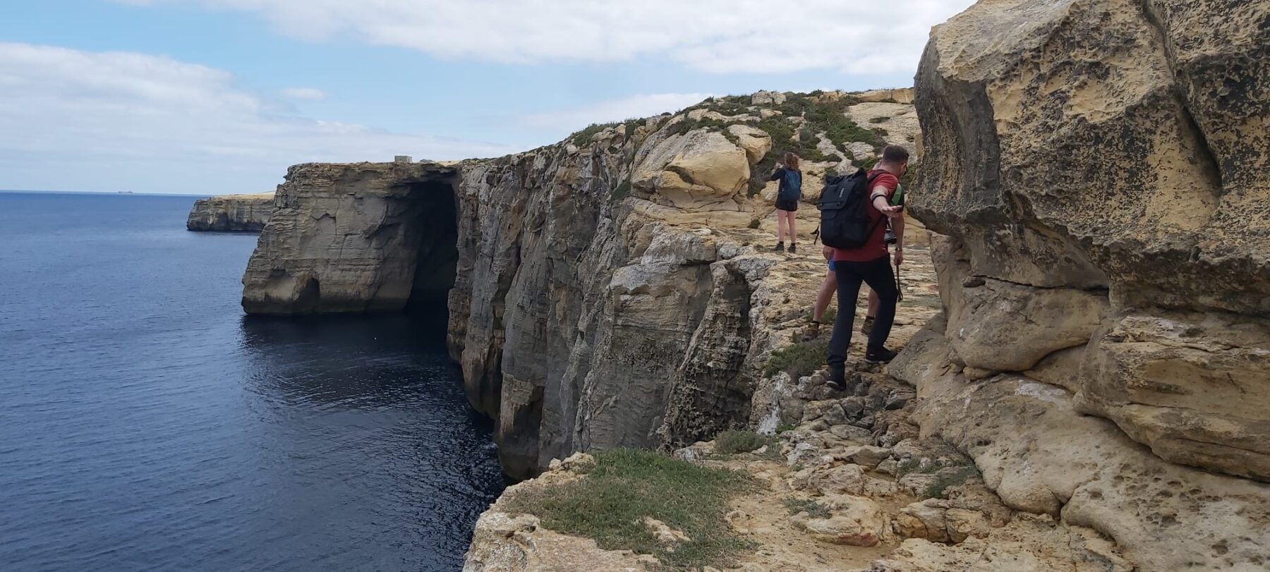 Hikers lopen over de rotskliffen van Malta 