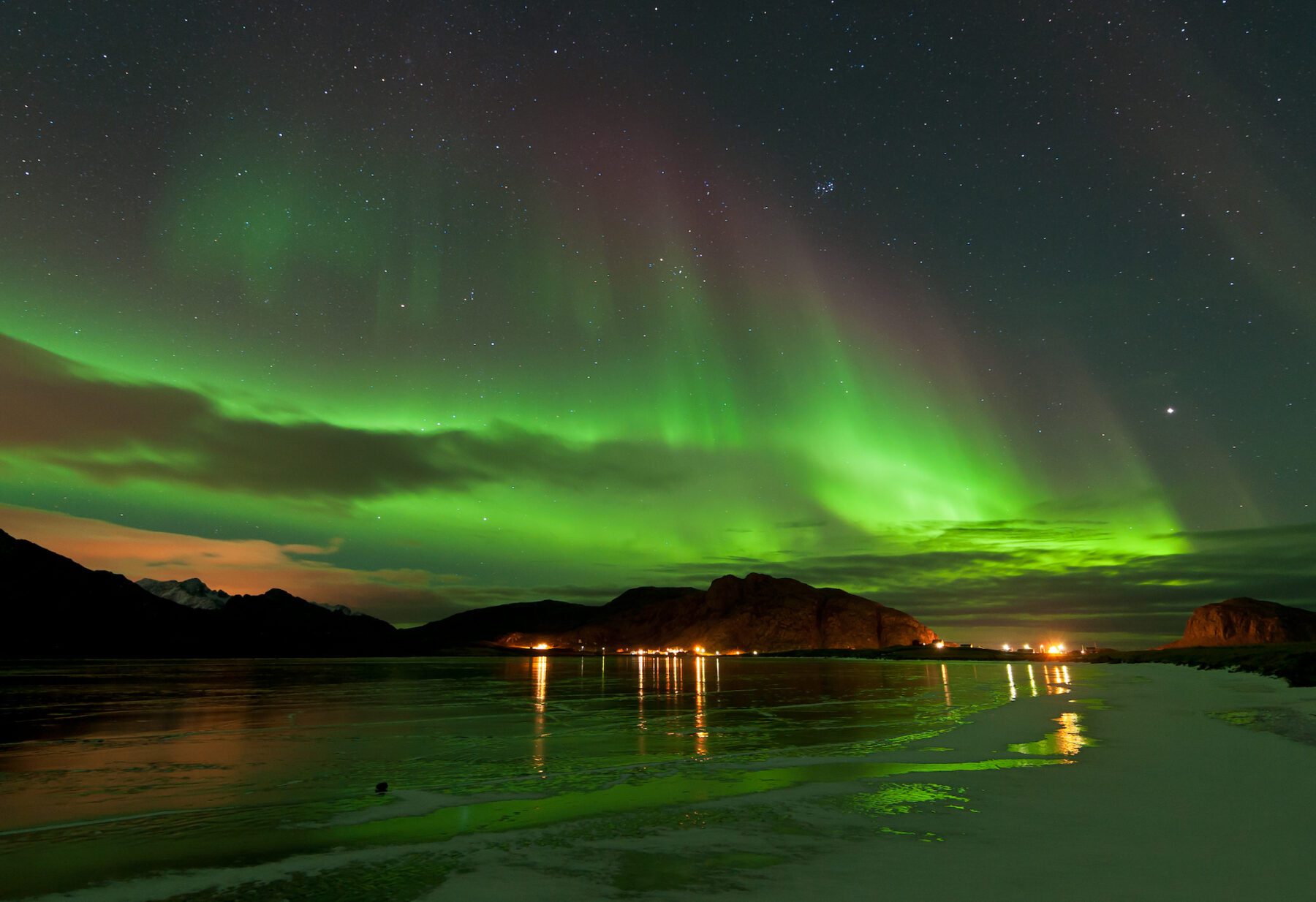 weerkaatsing van het noorderlicht op het water in Noord-Noorwegen