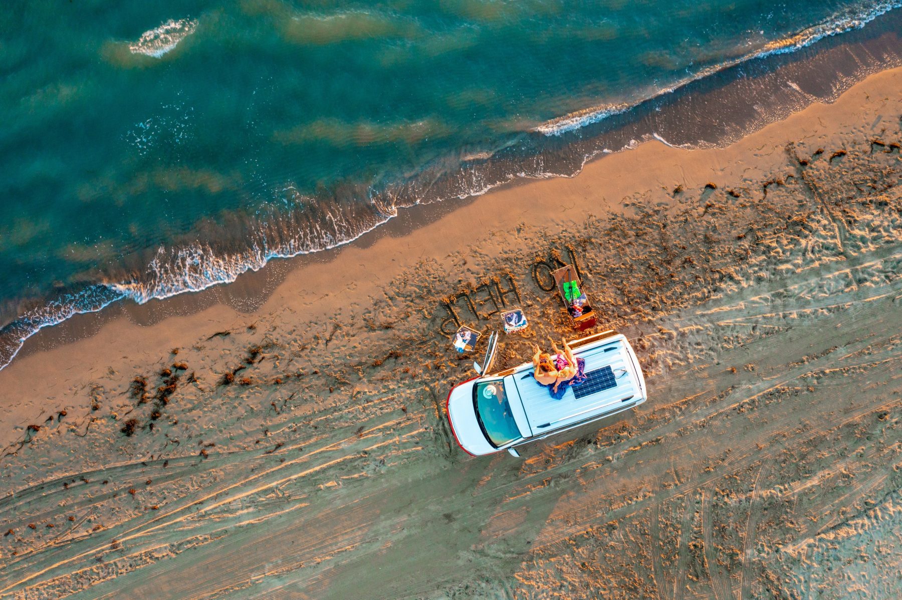 Twee mensen zittend op een bus op een strand in Albanië.