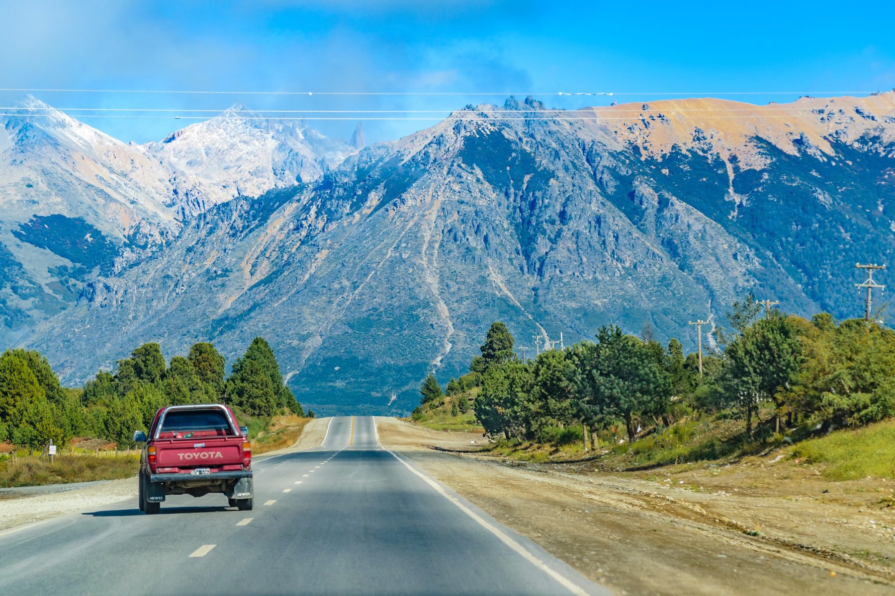 Auto rijdend door landschap Nieuw-Zeeland, één van de populaire bestemmingen in 2024 volgens Sunny Cars.