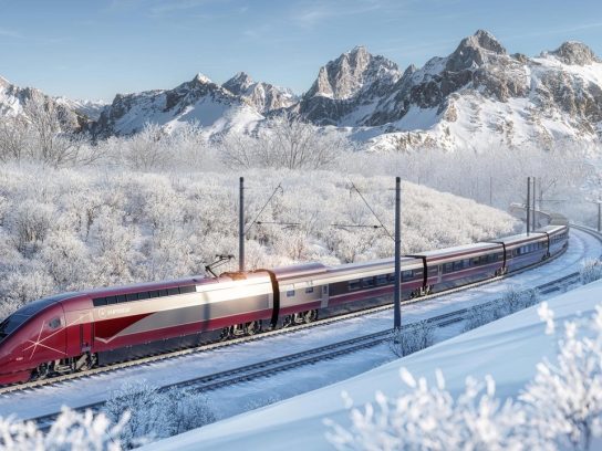 De Eurostar Snow rijdend door een besneeuwd landschap.