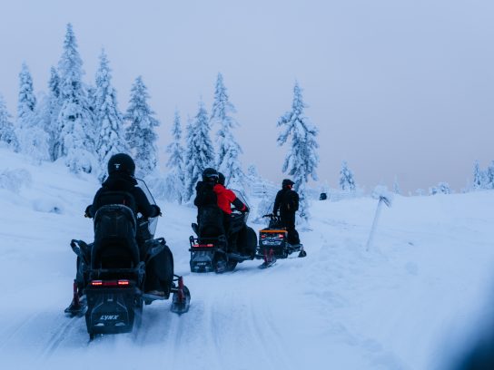 sneeuwscooters door een winters landschap in zweden