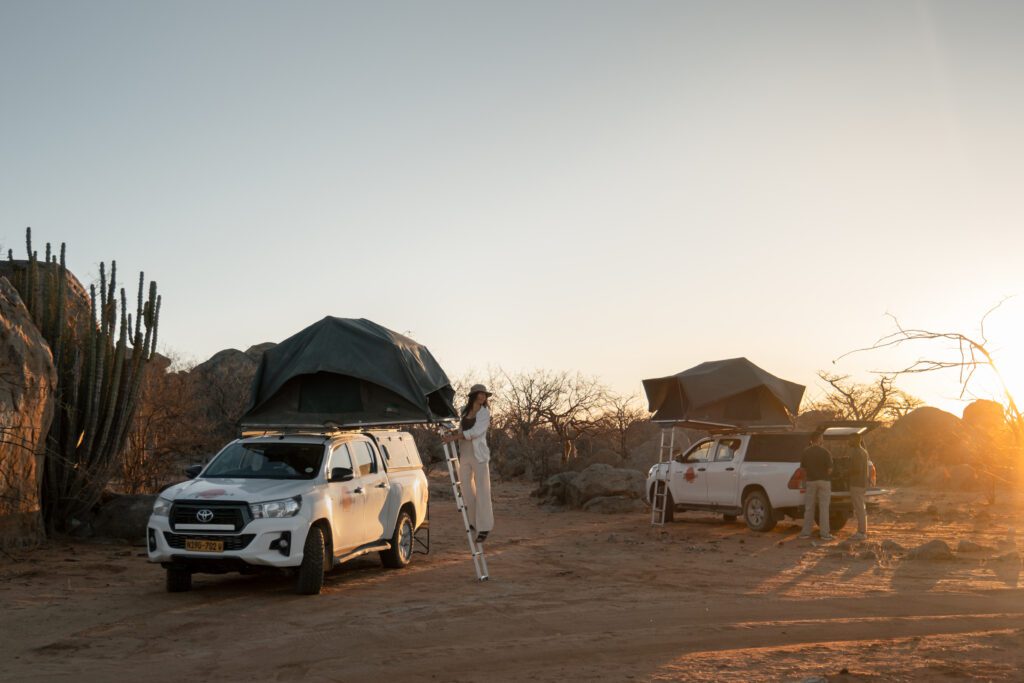 Mensen bij een auto met daktent in Namibië tijdens Namibia Nomads.