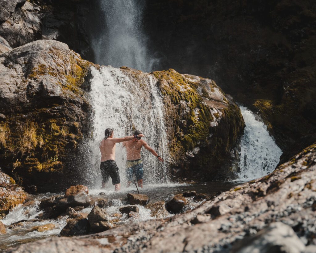 Twee personen bij een waterval in het Naerøyfjord in Noorwegen tijdens The Kayak Trip.