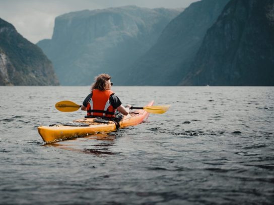 Persoon in een kayak in het Naerøyfjord in Noorwegen tijdens The Kayak Trip.