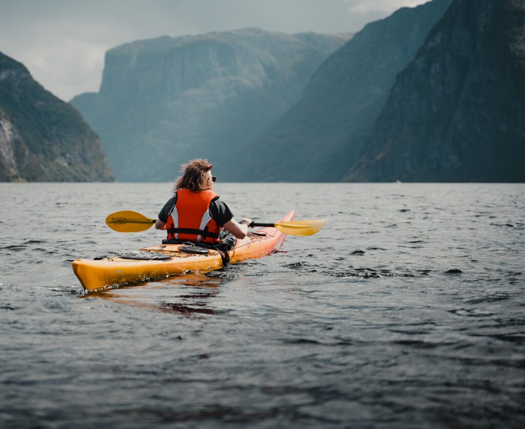 Persoon in een kayak in het Naerøyfjord in Noorwegen tijdens The Kayak Trip.