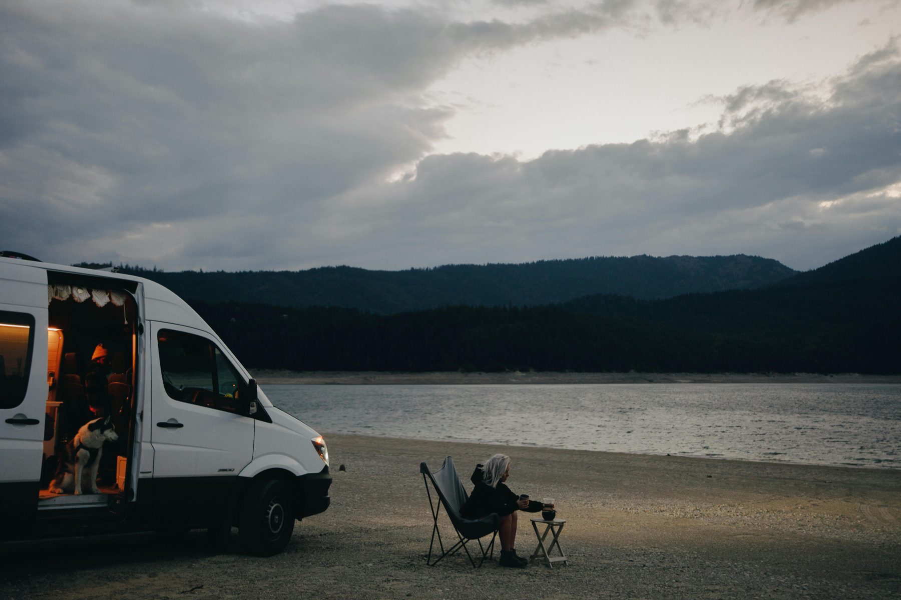 Mensen met hun camper aan het water.