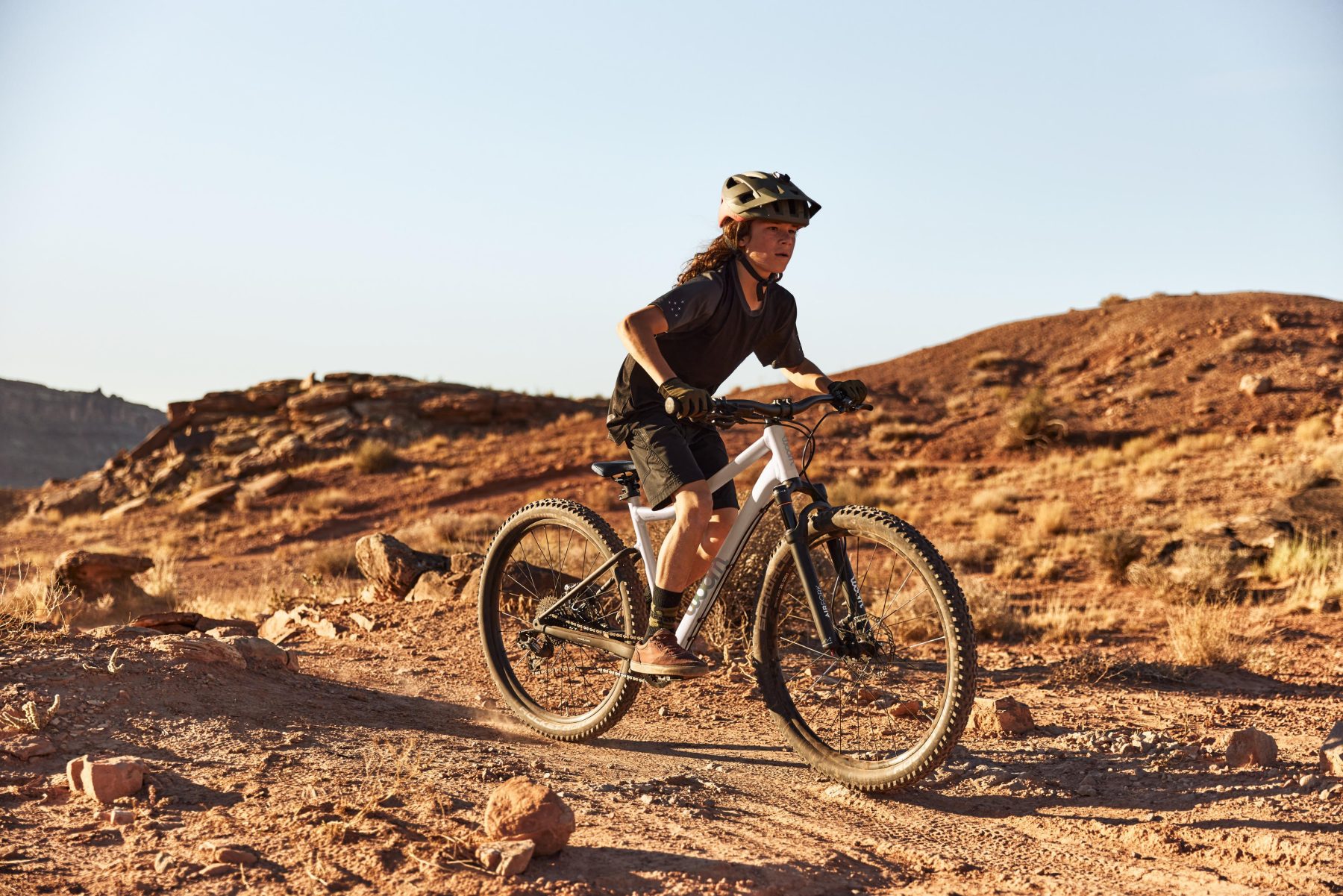 Een meisje op de limited edition Cirrus Cloud in een zandachtig gebied.