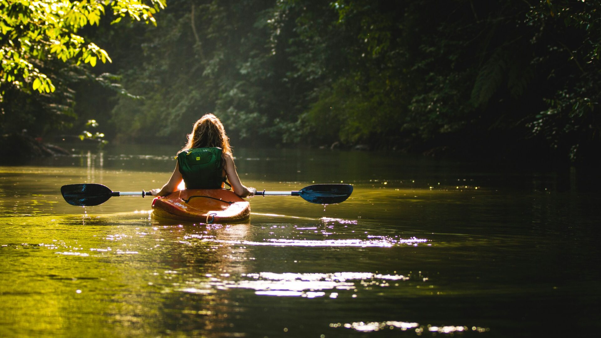 Vrouw in een kajak op een watervlakte in Costa Rica, waar Pura Vida een populaire levenshouding is.