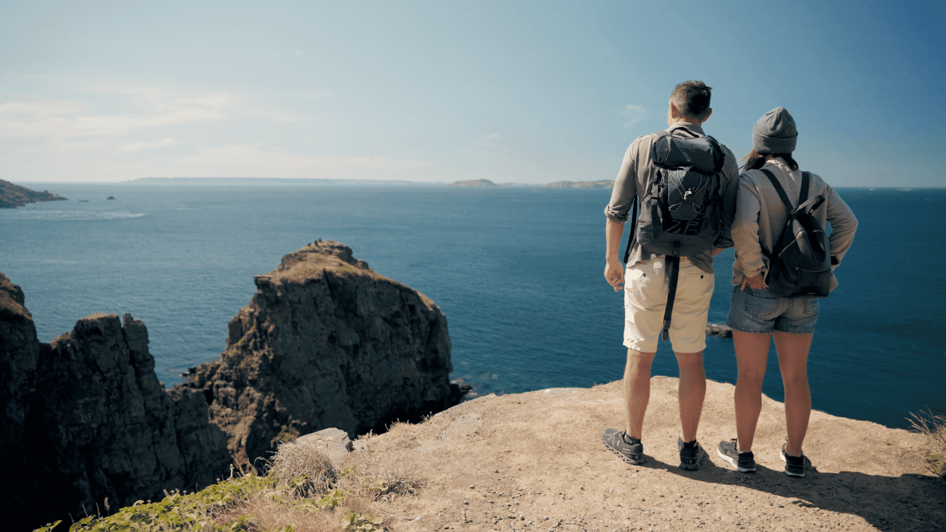 Twee mensen kijken uit over het water tijdens een hike op Sark.